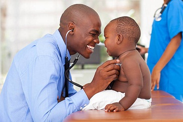 Black doctor attending to baby